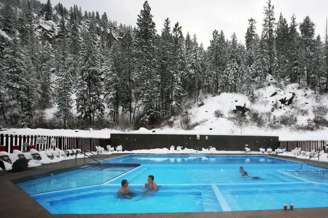 人们在被雪包围的温水泳池中嬉戏