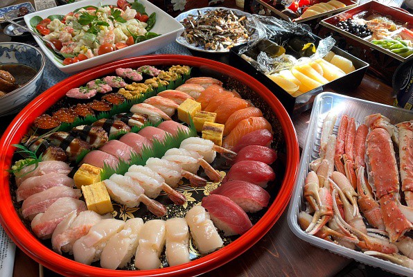 寿司拼盘、螃蟹和桌子上的各种日本料理。